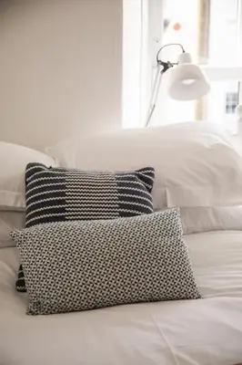 a black and white pillow on a white couch at Charming Cottage near Beach! in Redruth