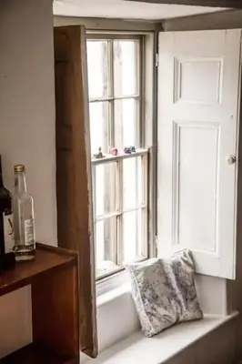 a window with a pillow sitting on a window sill at Charming Cottage near Beach! in Redruth
