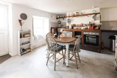 a kitchen with a table and chairs in a room at Charming Cottage near Beach! in Redruth