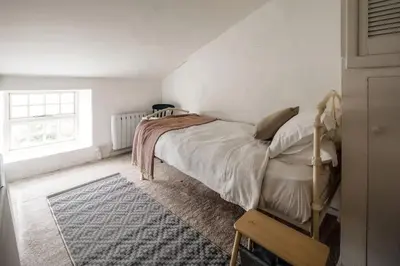 a bedroom with a bed and a window at Charming Cottage near Beach! in Redruth