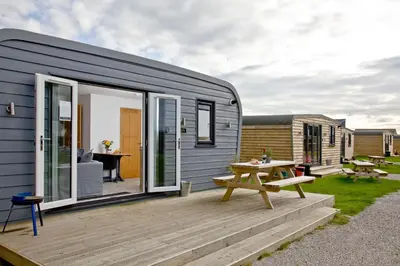 a tiny house with a deck and a picnic table at Wheal Tor - Free WiFi - Parking - Pet Friendly - On-site Activities in Helston