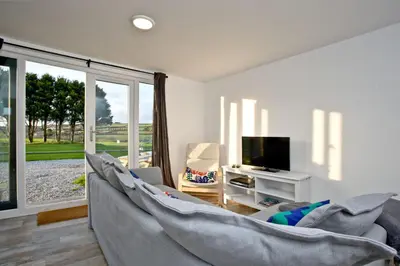 a living room with a couch and a tv at Wheal Amelia - Free WiFi - Parking - Pet Friendly - On-site Activities in Helston