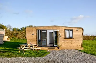a small wooden tiny house with a picnic table at Wheal Amelia - Free WiFi - Parking - Pet Friendly - On-site Activities in Helston