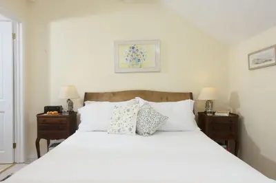 a bedroom with a bed with white sheets and pillows at Deugh an Chy in Carleen