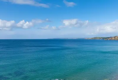 a large body of water with a blue sky and clouds at Deugh an Chy in Carleen