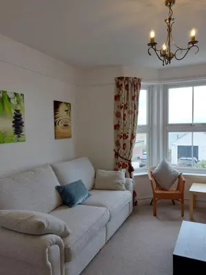 a living room with a couch and two windows at Porthmeor Beach 150 m Parking 2-3 cars in St Ives