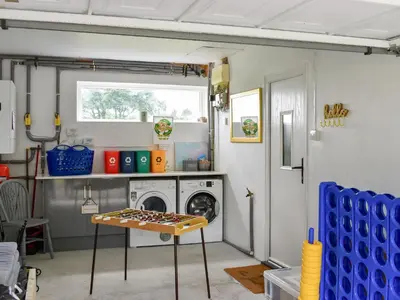 a laundry room with a washing machine and a table at Trelawney Bungalow in Callington