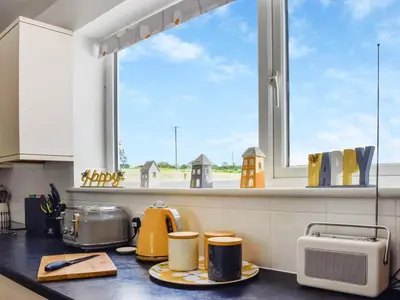 a kitchen with a counter with a window at Trelawney Bungalow in Callington
