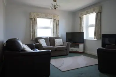 a living room with two couches and a television at Fabulous High Street Townhouse With Stunning Views & Parking at 'Eagles Nest' in Falmouth