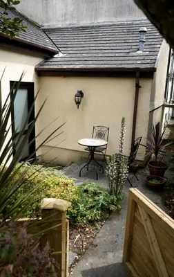 a patio with a table and chairs in a backyard at Fabulous High Street Townhouse With Stunning Views & Parking at 'Eagles Nest' in Falmouth