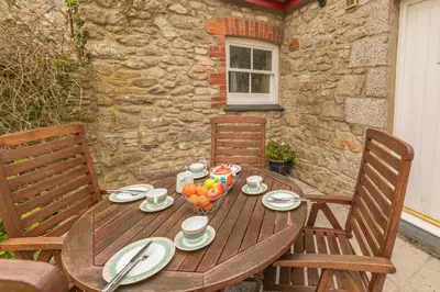 a wooden table with a bowl of fruit on it at 2 Bed in Ponsanooth oc-f28845 in Ponsanooth
