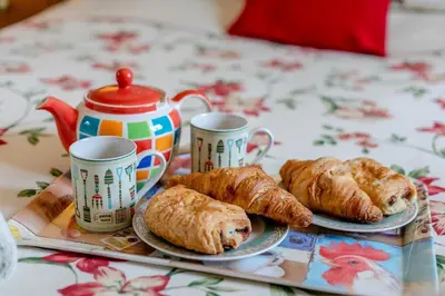 a table with two plates of croissants and cups of coffee at 2 Bed in Ponsanooth oc-f28845 in Ponsanooth