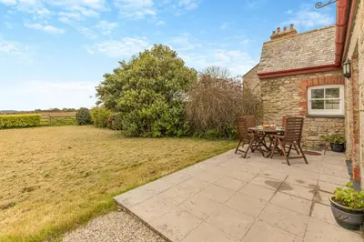 a patio with a table and chairs in front of a house at 2 Bed in Ponsanooth oc-f28845 in Ponsanooth
