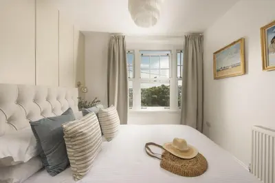 a hat sitting on top of a bed with pillows at 11 Tywarnhayle House, Perranporth in Perranporth