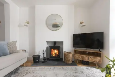 a living room with a fireplace and a flat screen tv at 11 Tywarnhayle House, Perranporth in Perranporth