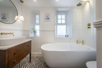 a white bathroom with a tub and a sink at 11 Tywarnhayle House, Perranporth in Perranporth
