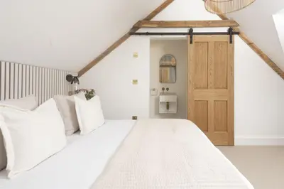 a bedroom with a white bed and a wooden door at 11 Tywarnhayle House, Perranporth in Perranporth