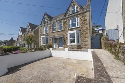 a large brick house with a driveway at 11 Tywarnhayle House, Perranporth in Perranporth