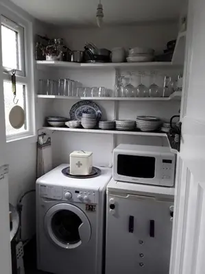 a kitchen with a washing machine and a microwave at Halcyon Days in Kenwyn
