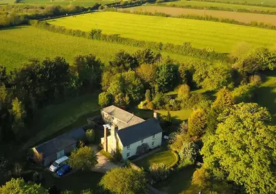 an aerial view of a house in the middle of a field at The Old Barn at Bosillion House in Grampound