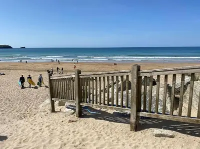 a group of people walking on the beach at Modern apartment, Fistral beach in Newquay