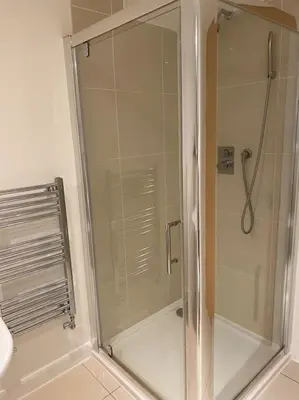 a shower with a glass door in a bathroom at Modern apartment, Fistral beach in Newquay