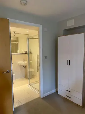 a bathroom with a shower and a white cabinet at Modern apartment, Fistral beach in Newquay