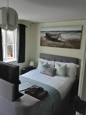 a bedroom with a bed and a picture of a boat at Freda's Treasure 