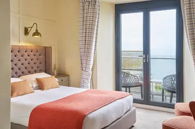a bedroom with a bed and a view of the ocean at Outlaw's Guest House in Port Isaac