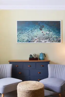 a living room with two chairs and a dresser at Outlaw's Guest House in Port Isaac