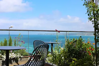 a balcony with a table and chairs and the ocean at Outlaw's Guest House in Port Isaac