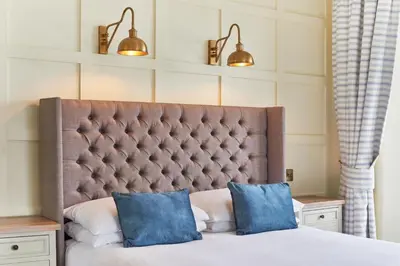 a bed with two blue pillows on top of it at Outlaw's Guest House in Port Isaac
