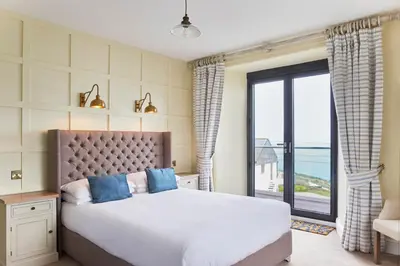 a bedroom with a large bed and a large window at Outlaw's Guest House in Port Isaac