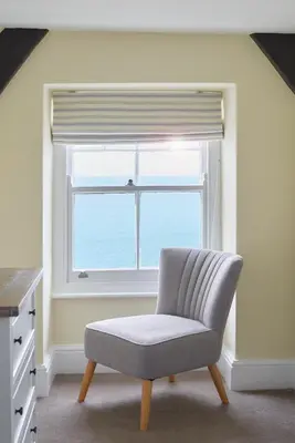 a chair in front of a window in a kitchen at Outlaw's Guest House in Port Isaac