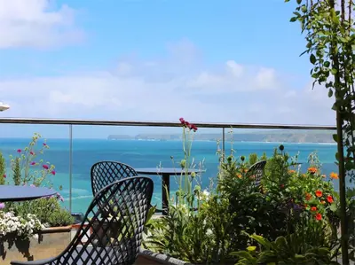a balcony with chairs and a view of the ocean at Outlaw's Guest House in Port Isaac