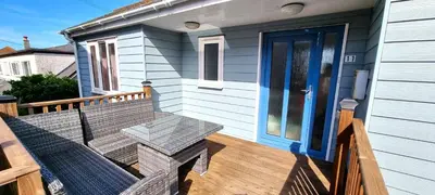 a porch with a bench and a blue door at Penaflor in Perranporth