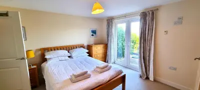 a bedroom with a bed and a large window at Penaflor in Perranporth