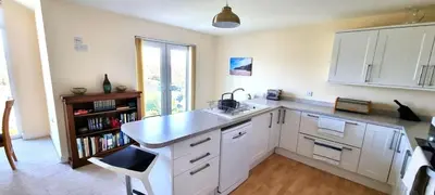 a kitchen with white cabinets and a sink at Penaflor in Perranporth