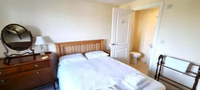 a bedroom with a bed with a mirror and a dresser at Penaflor in Perranporth