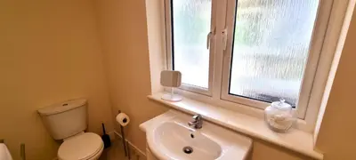 a bathroom with a toilet and a sink and a window at Penaflor in Perranporth