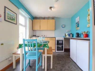 a kitchen with blue walls and a table and chairs at Skylarks! in St. Agnes