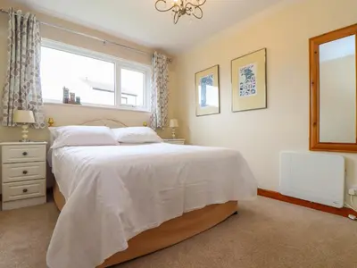 a bedroom with a white bed and a window at Skylarks! in St. Agnes