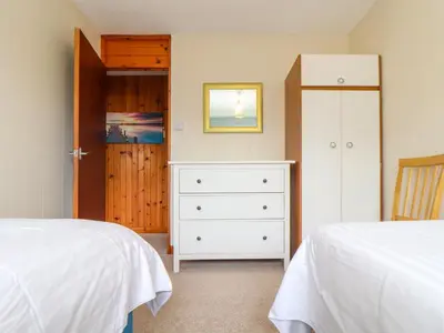 a bedroom with two beds and a dresser at Skylarks! in St. Agnes