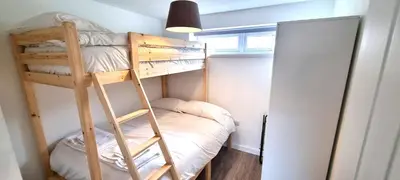 a bunk bed in a small room with a ladder at 5 Penhale in Perranporth