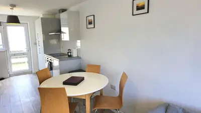 a kitchen with a table and chairs in a room at 5 Penhale in Perranporth