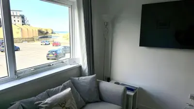 a living room with a couch and a window at 5 Penhale in Perranporth