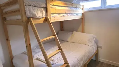 a bunk bed in a small room with a ladder at 5 Penhale in Perranporth