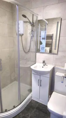 a bathroom with a shower and a sink and a toilet at 5 Penhale in Perranporth