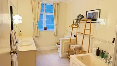a bathroom with a sink and a toilet and a window at Moorswater Lodge Country House with Wine Bar in Liskeard