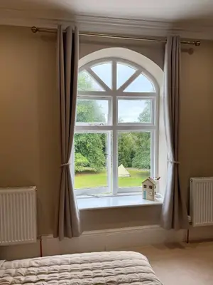 a bedroom with a large window with a view at Moorswater Lodge Country House with Wine Bar in Liskeard